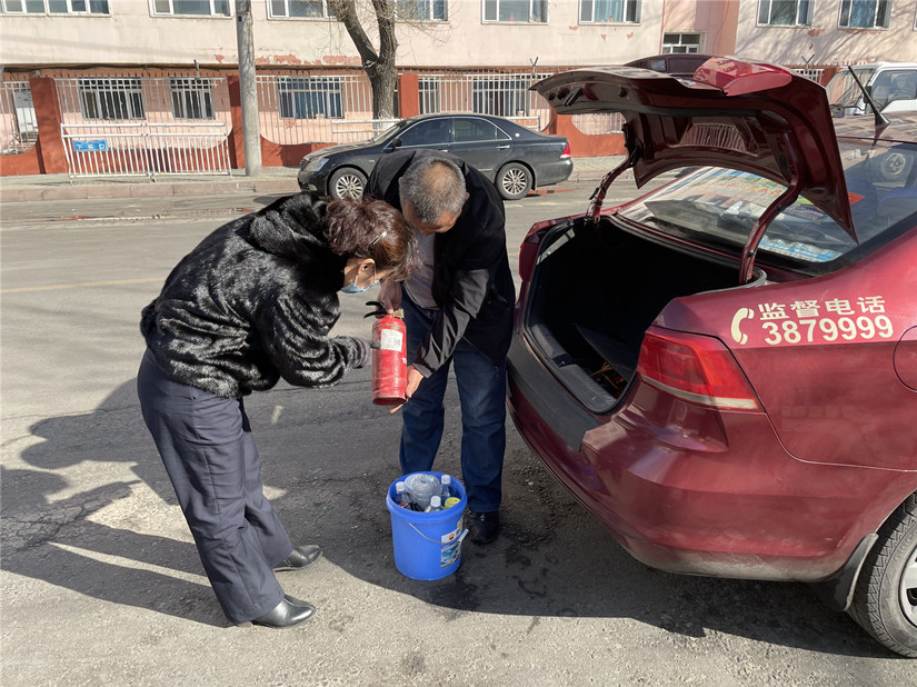 圖為：運(yùn)輸公司管理人員對(duì)出租車(chē)上滅火器的檢查_(kāi)副本.jpg